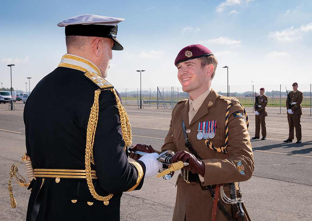 With the 47 AD parade in the background, Major Sam Kennedy, Officer Commanding 47 Air Despatch Squadron, receives the Firmin Sword of Peace from Vice Admiral Steve Moorhouse CBE.